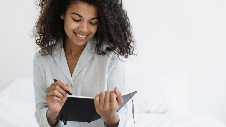 Smiling woman writing in journal