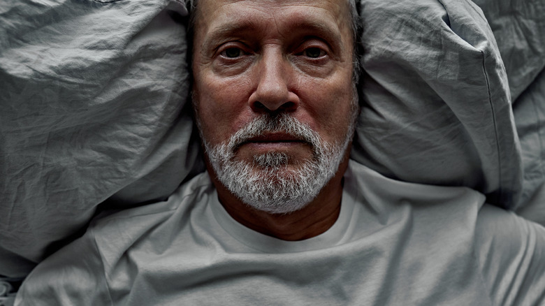 older man awake in bed