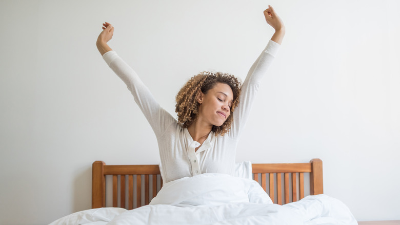 woman sitting up in bed after waking