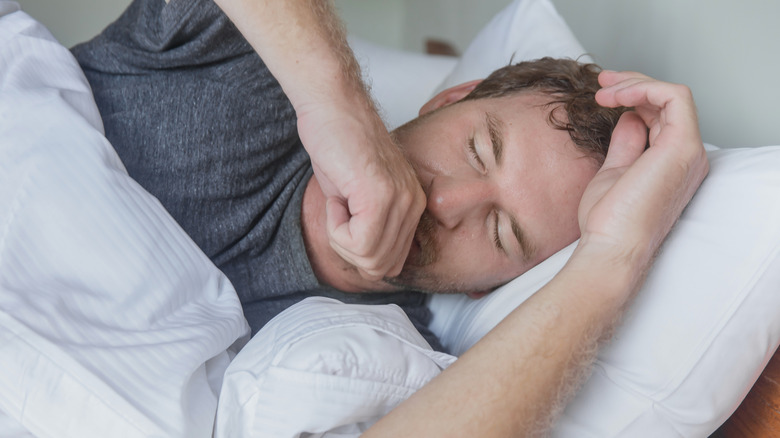 Woman coughing in bed