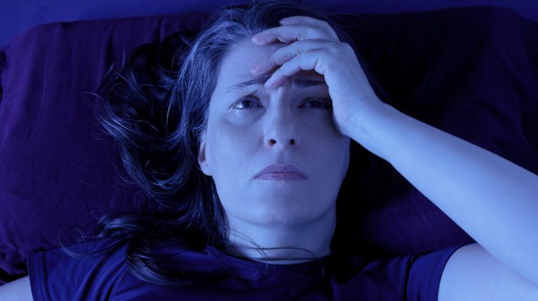 Worried woman awake in bed