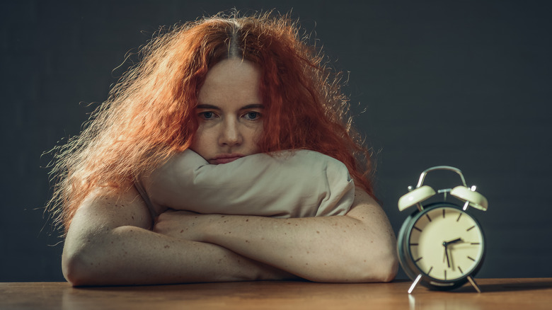 Tired woman holding pillow