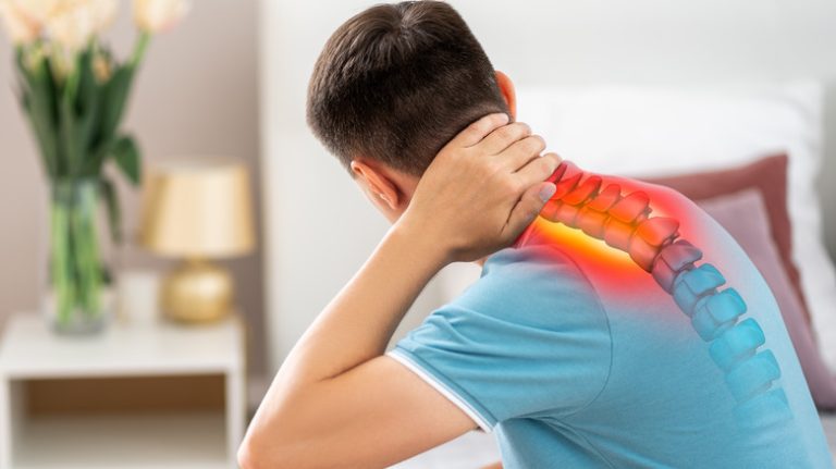 man holding neck after waking up because of pain