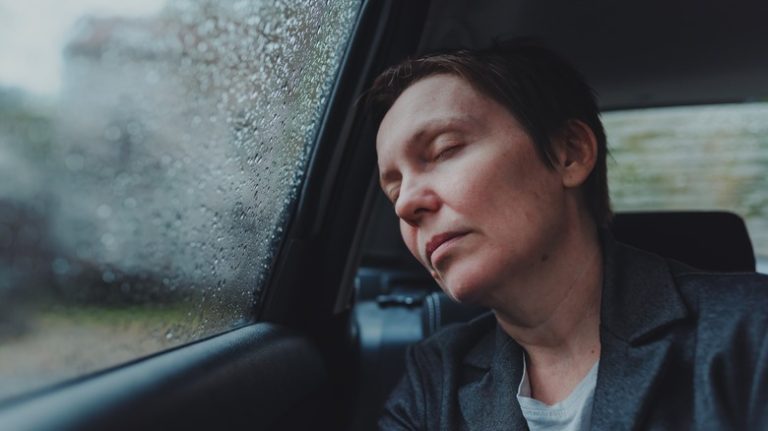 a woman falling asleep on a rainy day