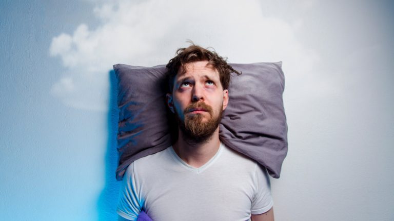 man with insomnia in bed