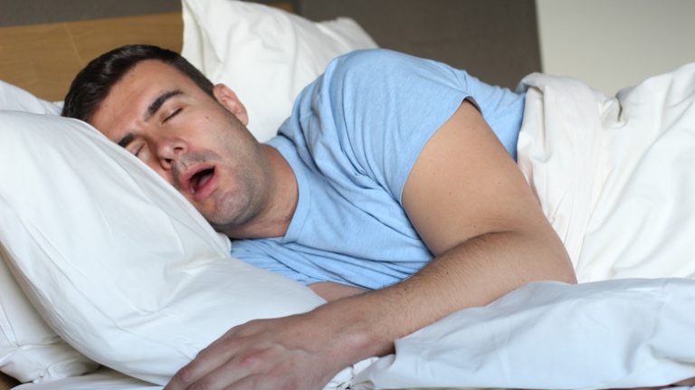 a middle aged man drooling while sleeping in bed