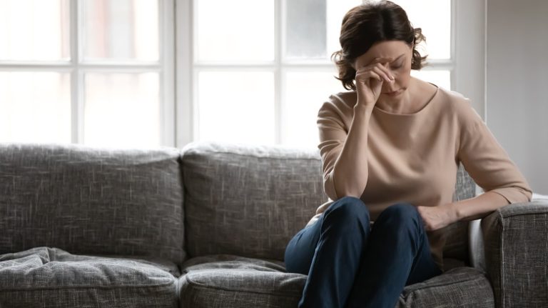 Sad woman sitting on couch