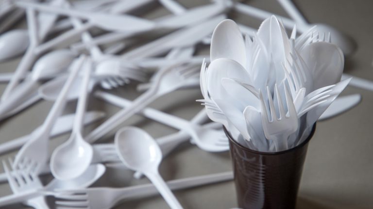 cup filled with plastic utensils