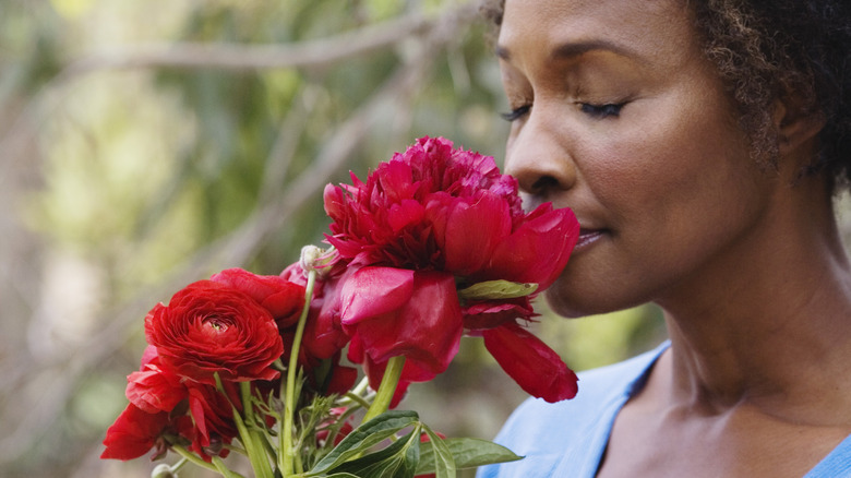 Woman smelling red peonies