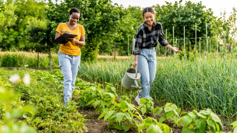 Two women walking through garden