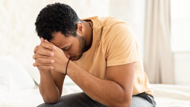 man with his head in hands suffering from depression