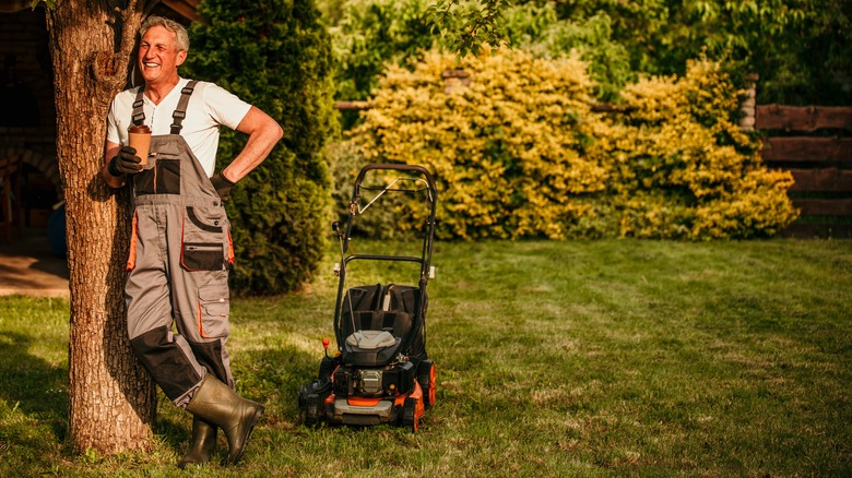 Man standing near lawnmower