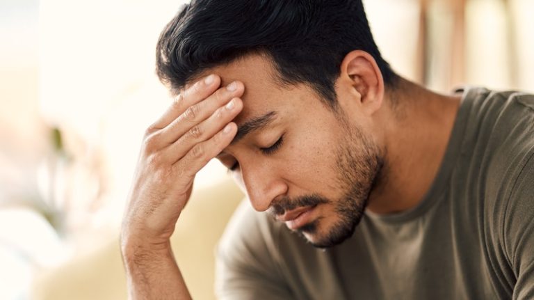 Anxious man touching forehead