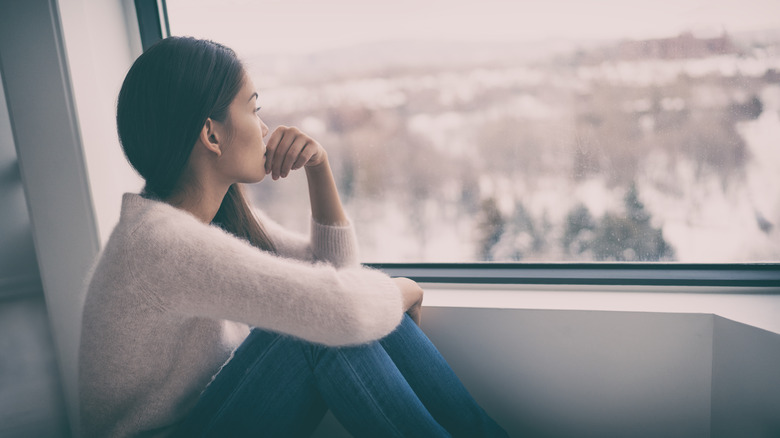 Young woman looking out window