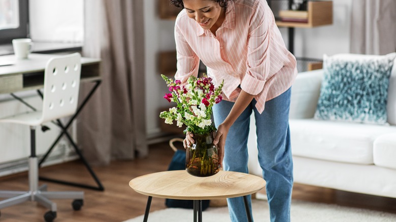 Person holding flower vase