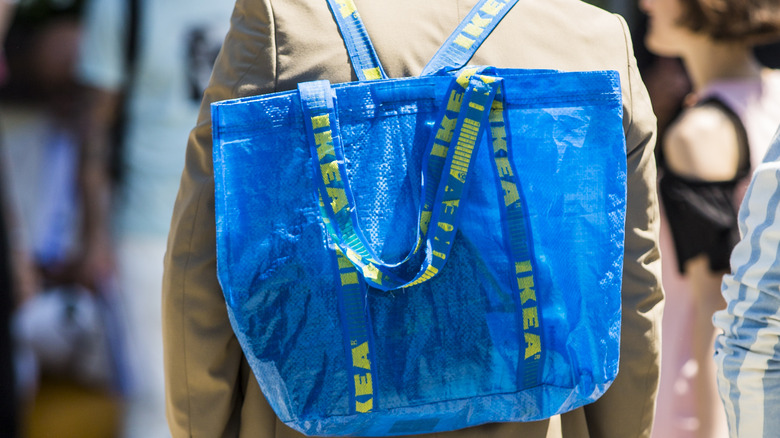 someone wearing blue IKEA shopping bag