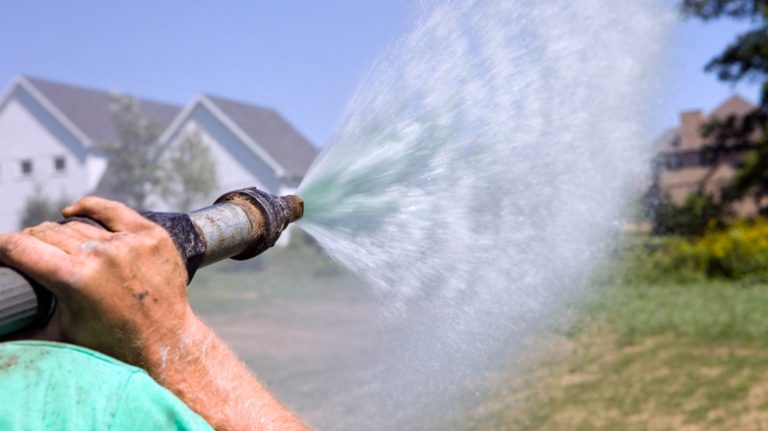 Man blasting hydroseed at lawn