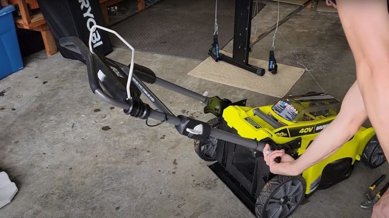 man adjusting mower handle