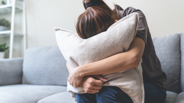 woman burying head in pillow