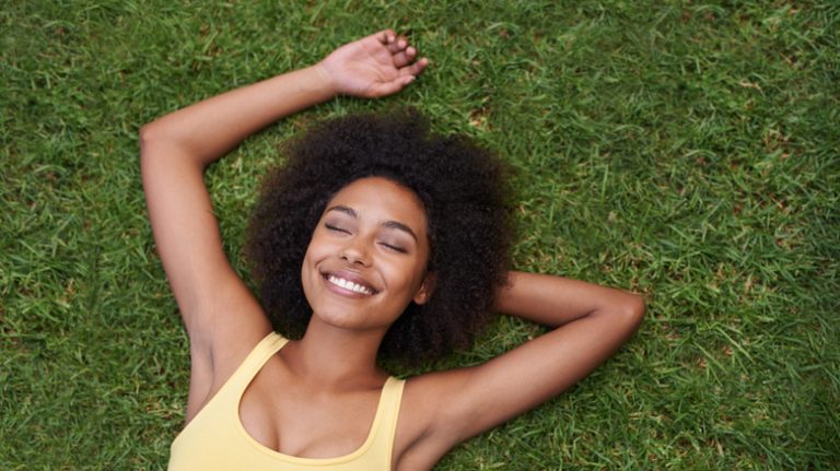 woman relaxing on green lawn