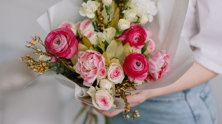 Person holding peony bunch