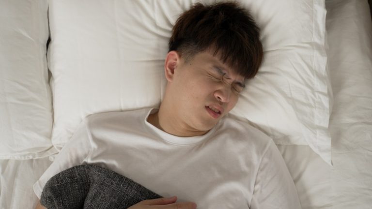 Man grimacing in sleep