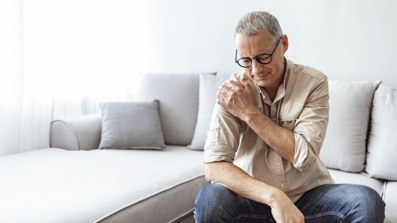 Wincing man with shoulder pain