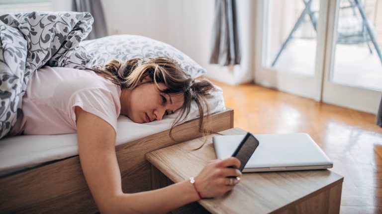 woman in bed looking at phone