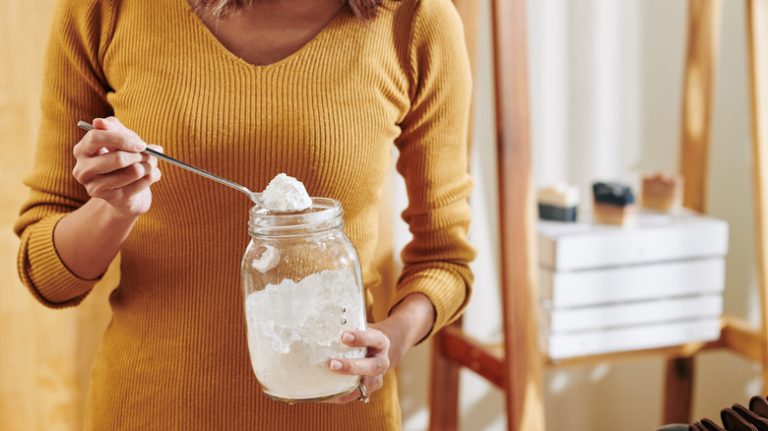 Person holding glass jar white powder