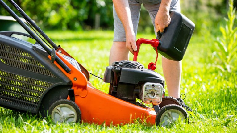 person pours gas into mower