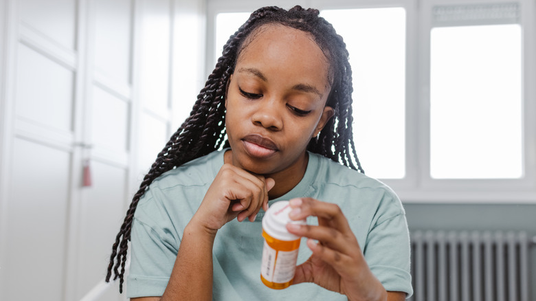 Woman reading prescription medication label