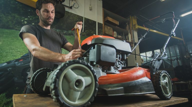 Person removing lawnmower spark plug