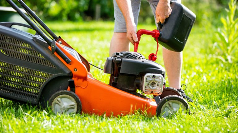 man topping up fuel in lawnmower