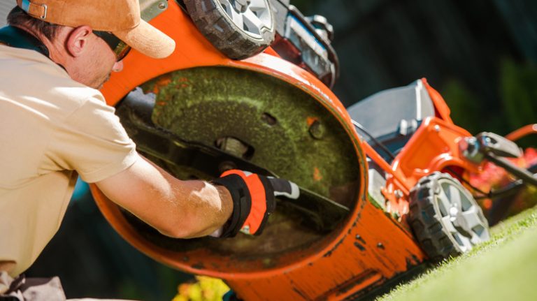 Person checking lawn mower blades