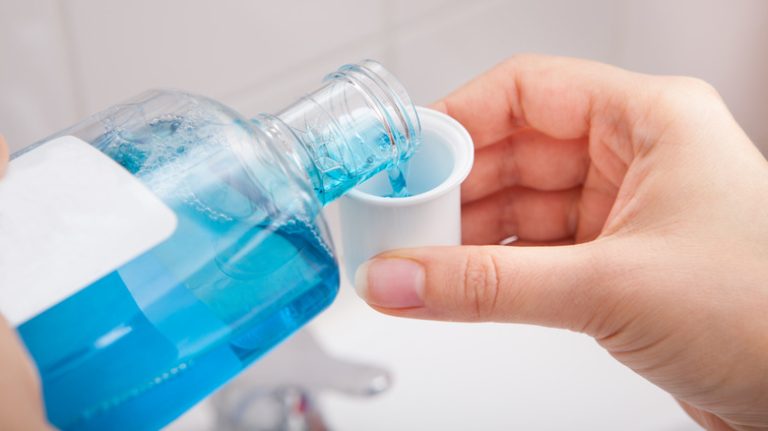 Pouring mouthwash into cup