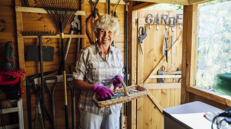 woman holding tools in shed