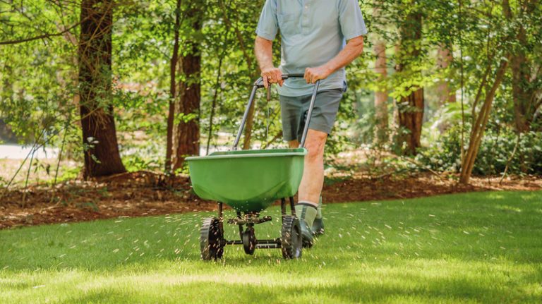 Man pushing wheelbarrow on lawn