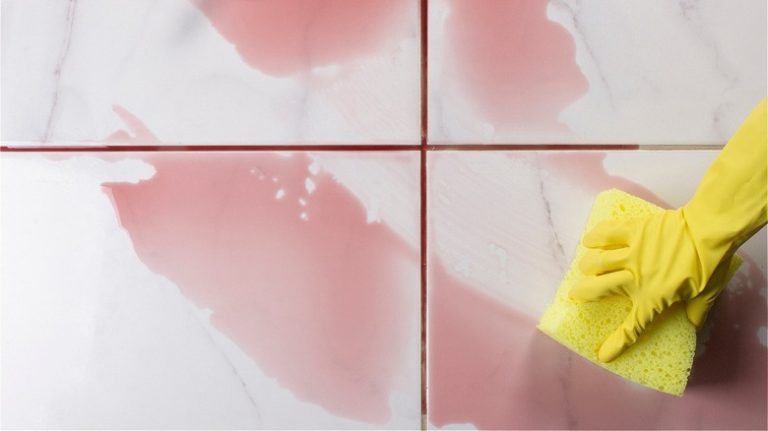 person cleaning wine from tile